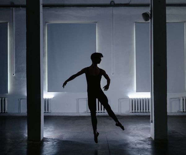 Man executing a perfect form push-up on a dark floor.